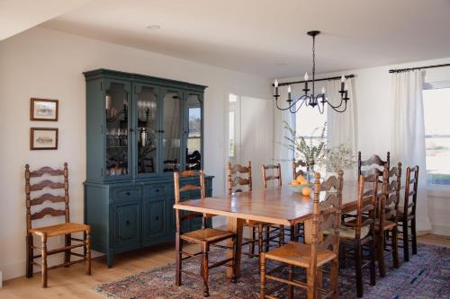 a dining room with a green cabinet and a wooden table at The Hull House - Lake Ontario Waterfront w Sauna in Wellington