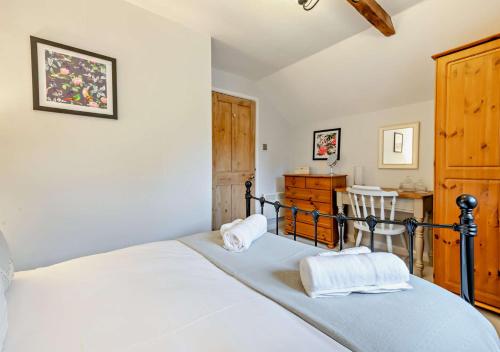 a bedroom with a bed with two towels on it at Wren Cottage - Bedale in Hornby