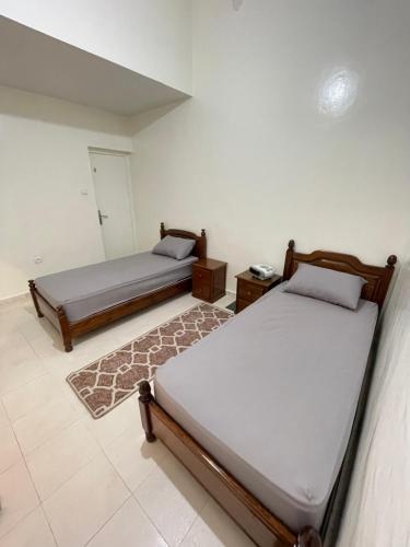 a bedroom with two beds and a rug at Cente ville House in Agadir