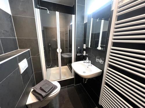 La salle de bains est pourvue d'un lavabo, d'une douche et de toilettes. dans l'établissement Cozy 1 room apartment in Zug, à Zoug