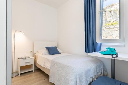 a small bedroom with a bed and a window at Seaview Vela Luka in Vela Luka