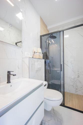 a white bathroom with a sink and a toilet at Beautiful Holiday Home "Villa Relax Oasis" in Trogir