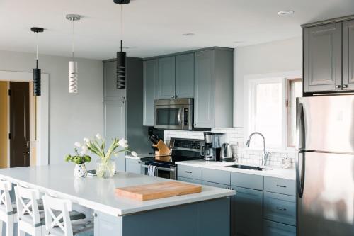 a kitchen with blue cabinets and a white counter top at Tanglewood - Large Waterfront Home in PEC in Waupoos