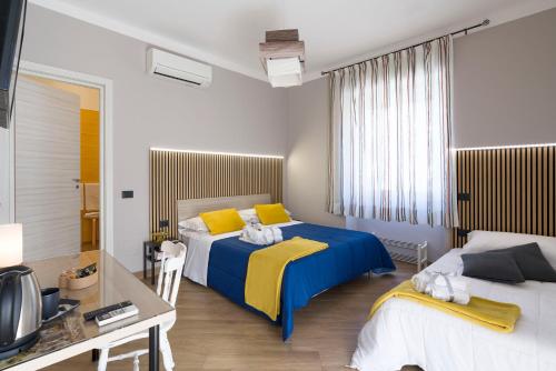 a bedroom with two beds with yellow and blue sheets at Il Tempio di Athena - Cultura e Relax a Siracusa in Siracusa