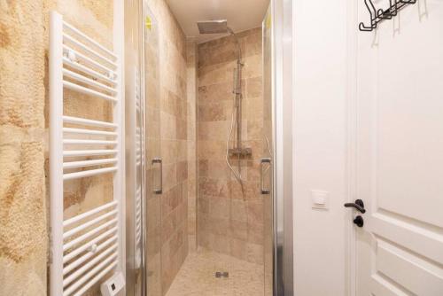 une salle de bain avec une douche avec une porte vitrée dans l'établissement Appartement 2 chambres Lyonnais, à Paris