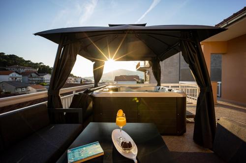 a balcony with a hot tub and a table with a drink at Beautiful Holiday Home "Villa Relax Oasis" in Trogir