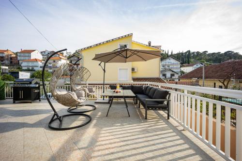 a balcony with a table and chairs and an umbrella at Beautiful Holiday Home "Villa Relax Oasis" in Trogir
