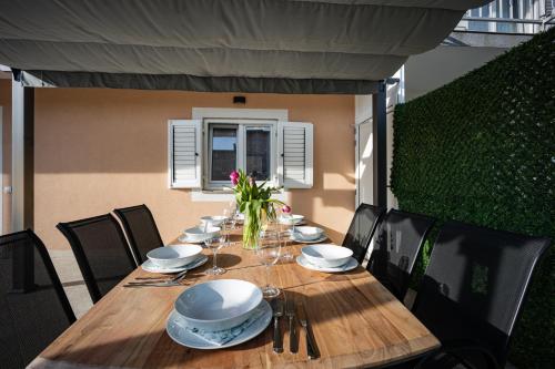 a wooden table with plates and napkins on it at Beautiful Holiday Home "Villa Relax Oasis" in Trogir