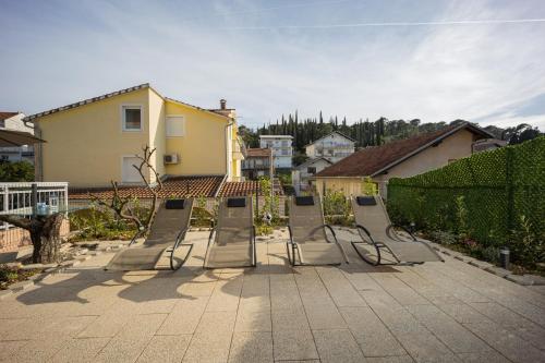 a row of chairs sitting on a patio at Beautiful Holiday Home "Villa Relax Oasis" in Trogir