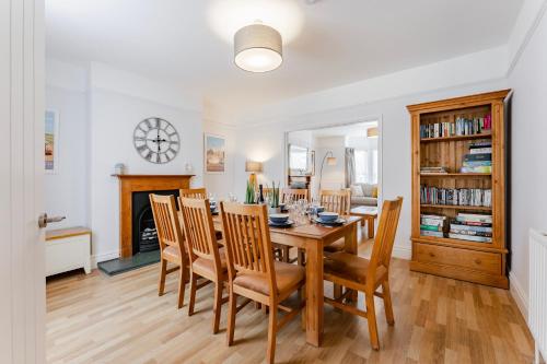 a dining room with a table and chairs and a fireplace at Barnacle Nook - Norfolk Cottage Agency in Sheringham