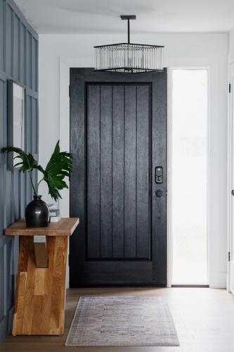 a black door with a potted plant on a wooden table at Wellers Landing - Prince Edward County Lakehouse in Carrying Place