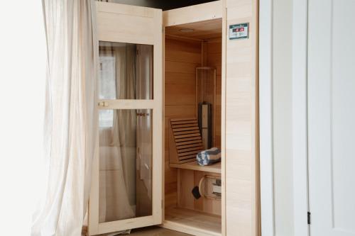 a room with a door to a kitchen with a refrigerator at Wellers Landing - Prince Edward County Lakehouse in Carrying Place