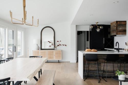 a kitchen with a table and a dining room at Wellers Landing - Prince Edward County Lakehouse in Carrying Place
