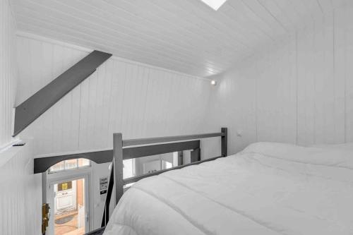 une chambre blanche avec un lit et une fenêtre dans l'établissement Le Matabiau, à Toulouse