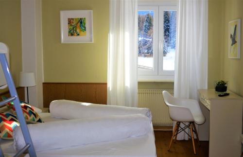 a bedroom with a bed and a window and a chair at Park Hotel Sancelso in Bellamonte