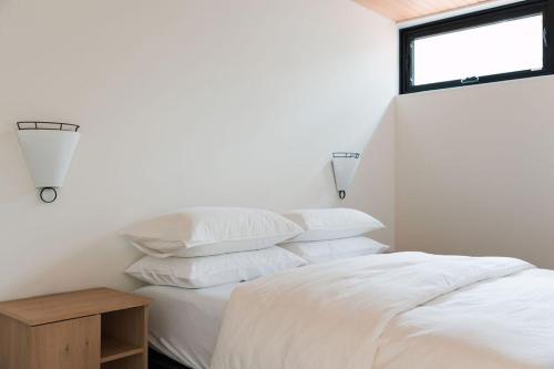 a bedroom with a bed with white sheets and a window at nortehaus - Nordic and Japanese inspired escape in Norland