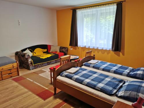 ein Wohnzimmer mit 2 Betten und einem Sofa in der Unterkunft Glázer Szállás in Tapolca