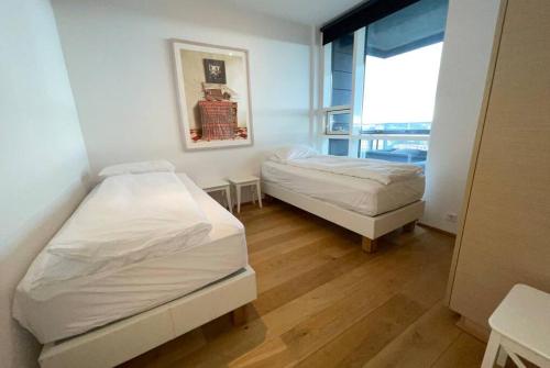 twee bedden in een kleine kamer met een raam bij Luxury apartment downtown Reykjavik with stunning views in Reykjavík