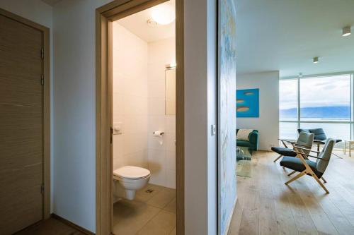 een badkamer met een toilet en een kamer met stoelen bij Luxury apartment downtown Reykjavik with stunning views in Reykjavík