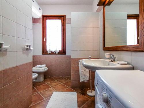 une salle de bain avec un lavabo, des toilettes et un miroir dans l'établissement Corallo City View, à Santa Teresa Gallura