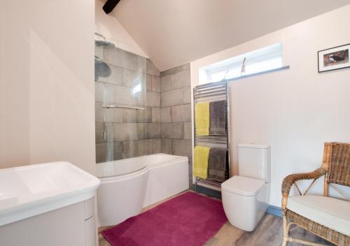 a bathroom with a tub and a sink and a toilet at Woodpecker View in Kirby Misperton