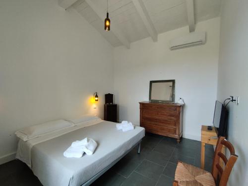 SUITE Rooms in Tenuta Asinara Vineyard في سورسو: غرفة نوم بسرير وخزانة وتلفزيون
