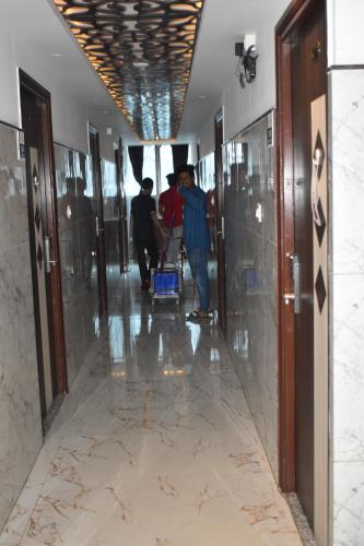 a group of people walking down a hallway in a building at Hotel UR Comforts Jayanagar in Bengaluru