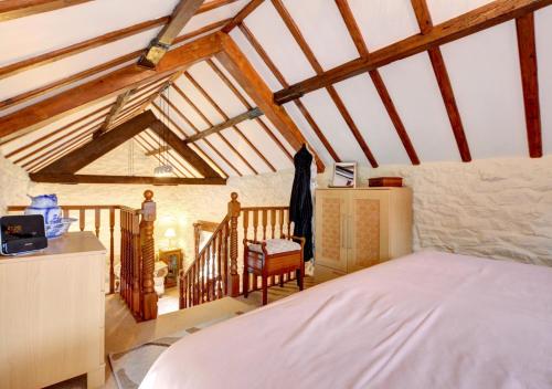 a bedroom with a bed in a room with wooden ceilings at Woodpecker Cottage in Hutton le Hole