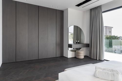 a bedroom with a white bed and a mirror at Palm Jumeirah Paradise - 5BR Villa - Infinity Pool in Dubai