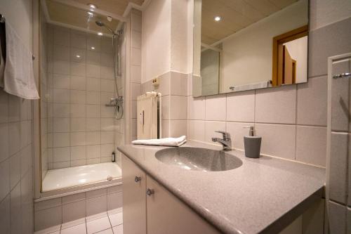 a bathroom with a sink and a mirror and a tub at Seemeile in Büsum