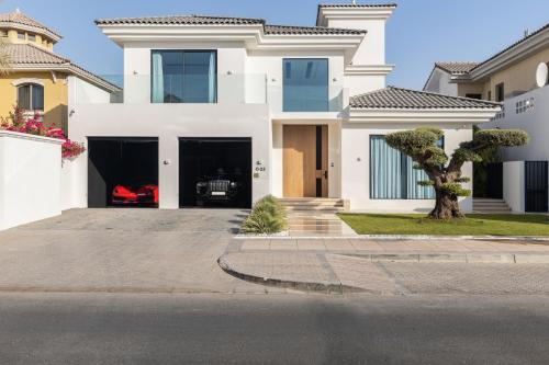 a white house with a driveway at Palm Jumeirah Paradise - 5BR Villa - Infinity Pool in Dubai