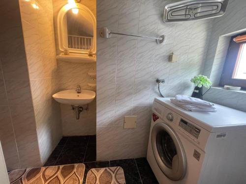 a bathroom with a washing machine and a sink at Family Residence Petrovac in Petrovac na Moru