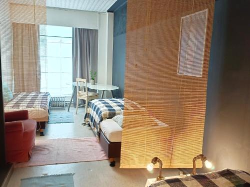 a room with a bedroom with a couch and a table at Lounge-Style-Hostel in Sankt Veit an der Glan