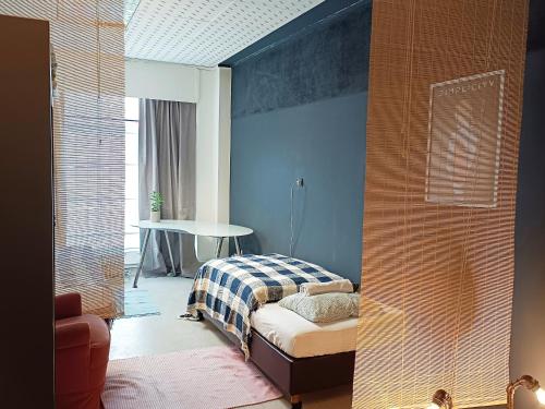 a bedroom with a bed and a table in a room at Lounge-Style-Hostel in Sankt Veit an der Glan
