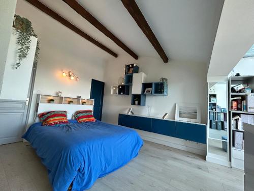 1 dormitorio con 1 cama con sábanas azules y almohadas rojas en maison entièrement climatisée vue d'exception mer et rade de Marseille avec piscine 8 personnes, en Marsella