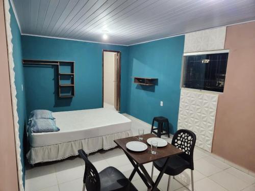 a room with a bed and a table and chairs at Kitnet Arretada São João in Campina Grande