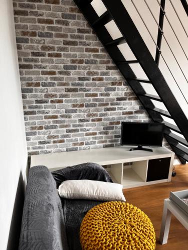 ein Wohnzimmer mit einem Sofa und einem Schreibtisch in der Unterkunft Appartement Saint Germain en Laye in Saint-Germain-en-Laye