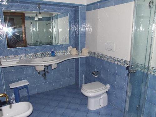 a blue tiled bathroom with a toilet and a sink at Aiano Bed&Breakfast in Capri