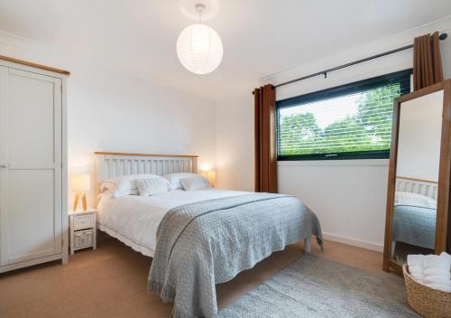 sypialnia z łóżkiem i dużym oknem w obiekcie Wildewood Cottage w mieście Robin Hood's Bay