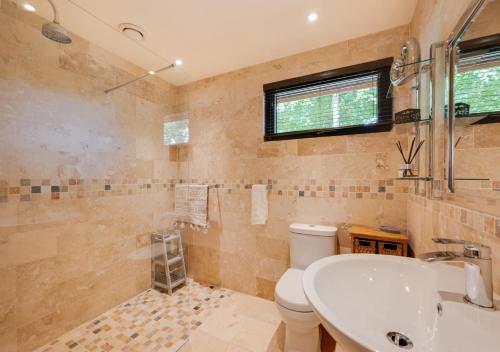 W łazience znajduje się umywalka, toaleta i prysznic. w obiekcie Wildewood Cottage w mieście Robin Hood's Bay