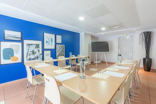 a conference room with a large table and a tv at Appart'City Confort La Ciotat - Côté Port in La Ciotat