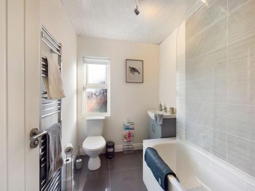 a bathroom with a tub and a toilet and a sink at It's Broadway Baby! Great house close to City Centre in Belfast