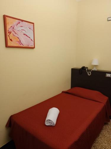 a bedroom with a red bed with a white pillow on it at Hotel Palace in Varazze