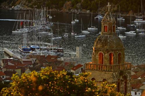 a building with a tower in a harbor with boats at Villa Kuljis in Komiža