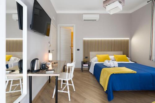 a bedroom with a bed and a table and a desk at Il Tempio di Athena - Cultura e Relax a Siracusa in Siracusa