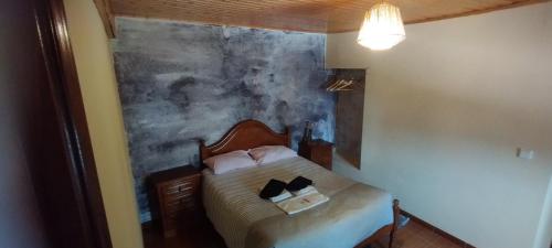 1 dormitorio con 1 cama con una pintura en la pared en Recanto da Costa, en Riba de Mouro