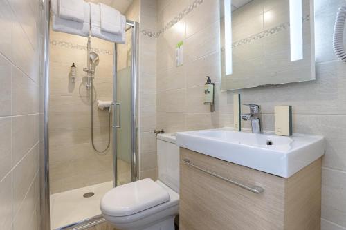 a bathroom with a sink and a shower and a toilet at Hotel De Paris in Boulogne-Billancourt