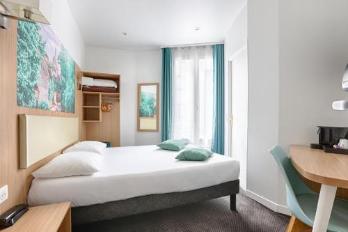 a hotel room with a bed and a window at Hotel De Paris in Boulogne-Billancourt