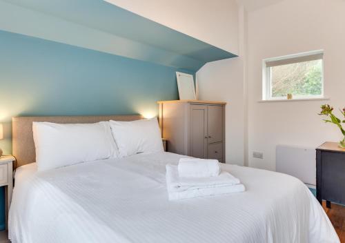 een slaapkamer met een bed met witte lakens en een raam bij The Trefanny Inn in Duloe