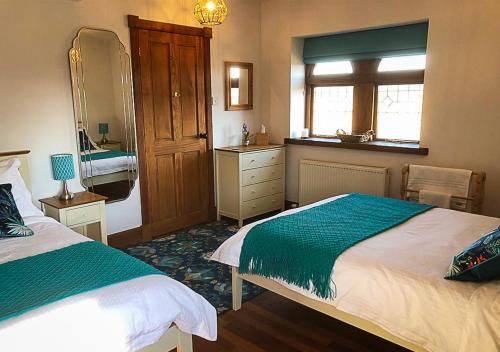 a bedroom with two beds and a sink and a mirror at The Tower, Moray Firth Holiday Home in Kinloss